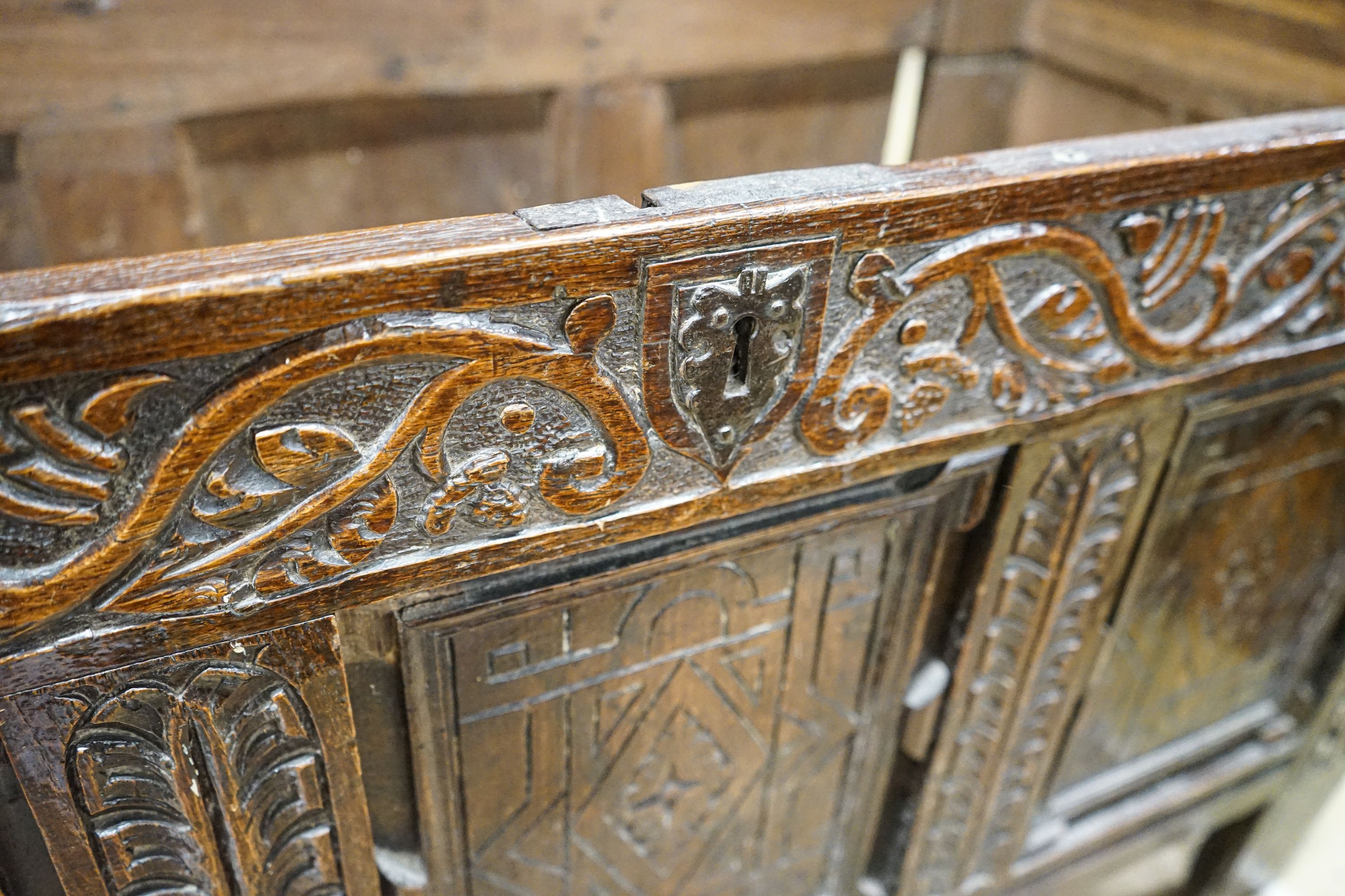 A 17th century oak coffer, with later carved front, length 120cm, depth 56cm, height 69cm
